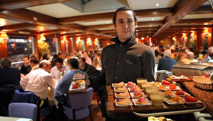 This is a picture of the waiter on a peniche, which is a nice restaurant in paris.