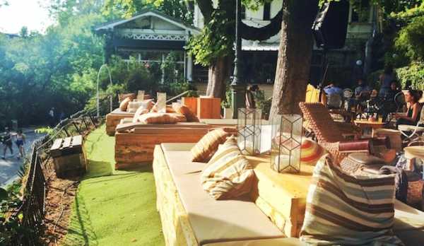 This is a picture of the terrace of a nice restaurant bar in Paris. And people are sitting.