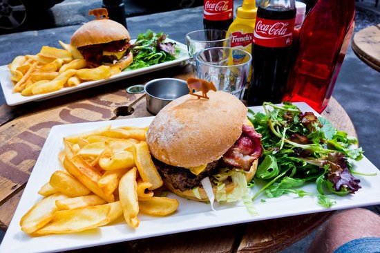 This is a picture of hamburgers fries and coca-cola in a restaurant in paris.